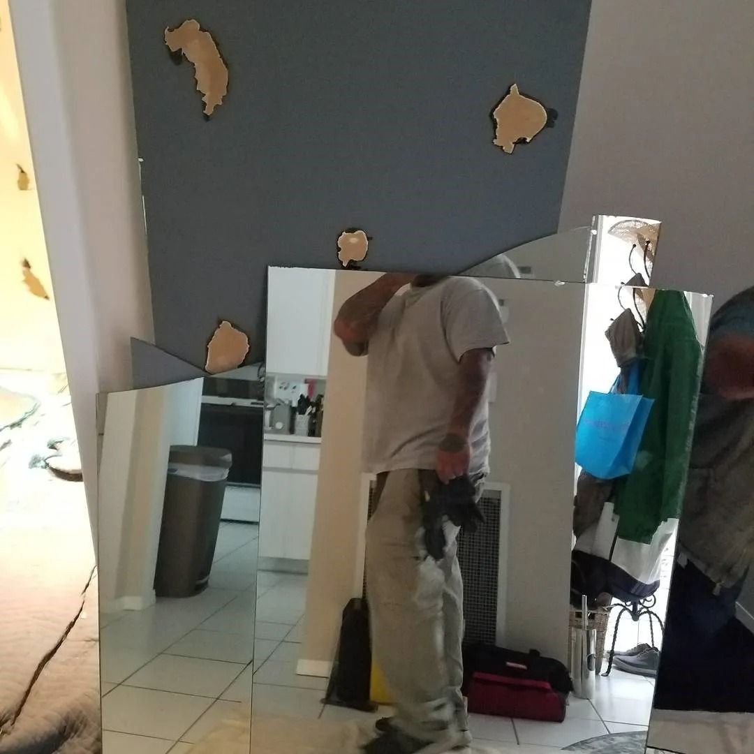 A man is standing in front of a mirror in a room