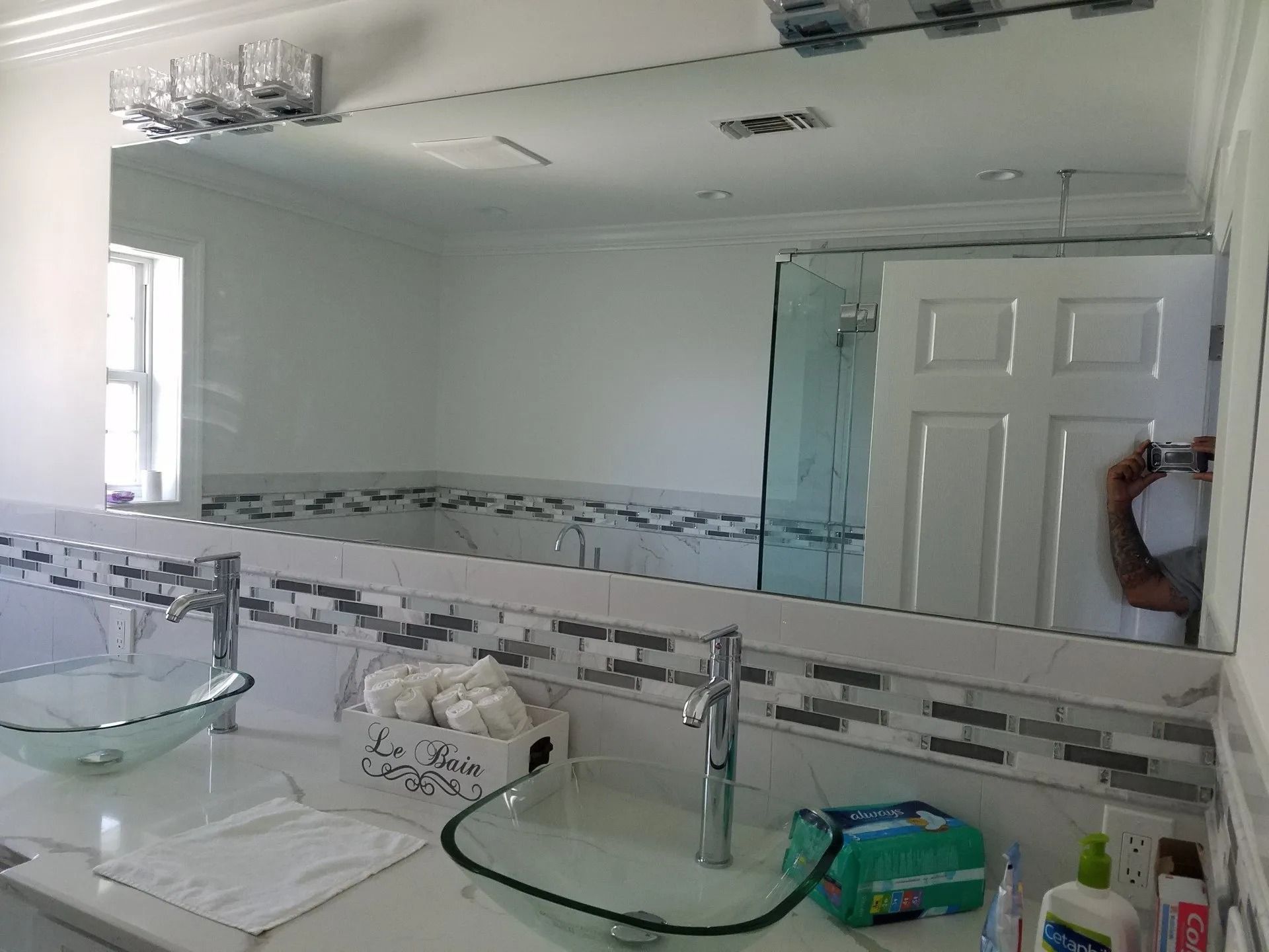 A bathroom with two sinks and a large mirror
