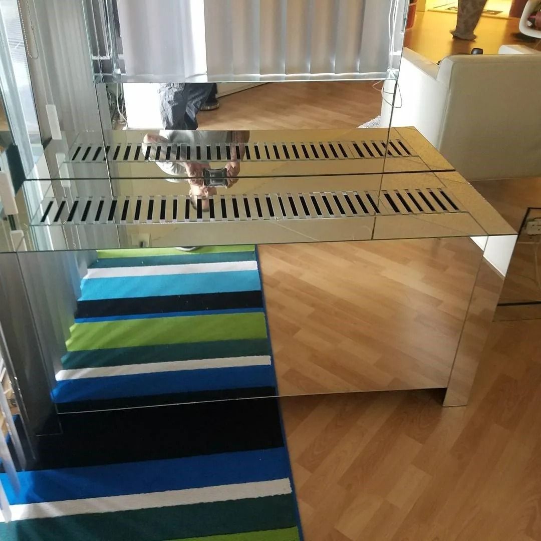 A striped rug is on the floor in front of a mirror
