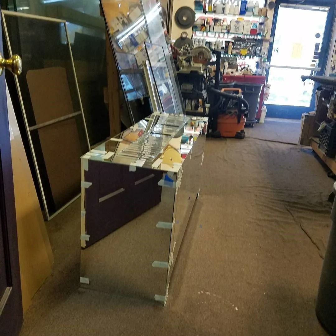 A mirror in a store with a vacuum cleaner in the background