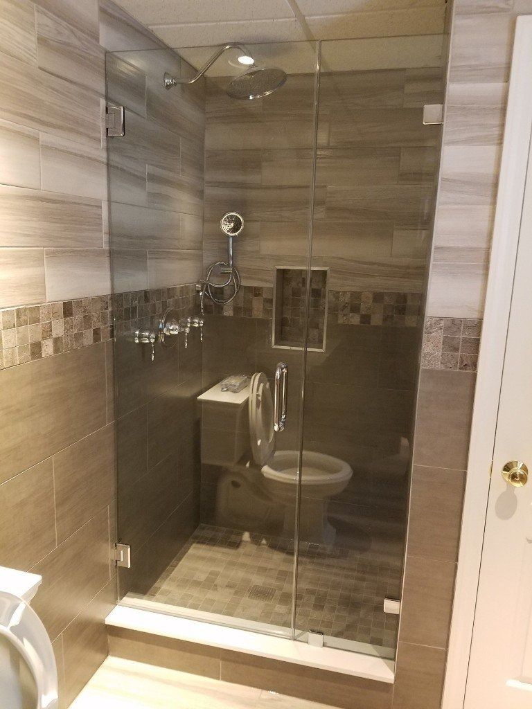 A bathroom with a toilet and a shower stall with a glass door.