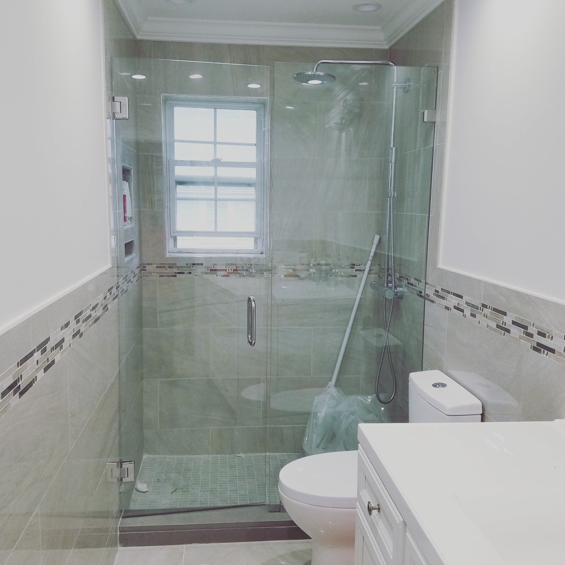 A bathroom with a toilet and a glass shower door