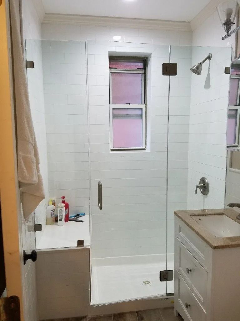 A bathroom with a walk in shower and a sink.