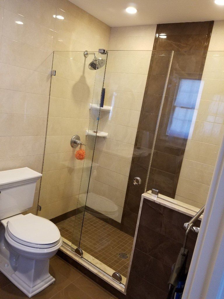 A bathroom with a toilet and a walk in shower.