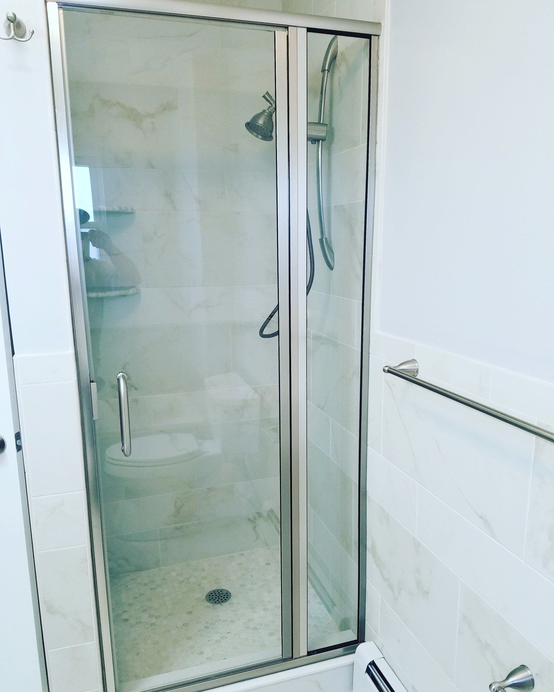 A bathroom with a glass shower door and a shower head.