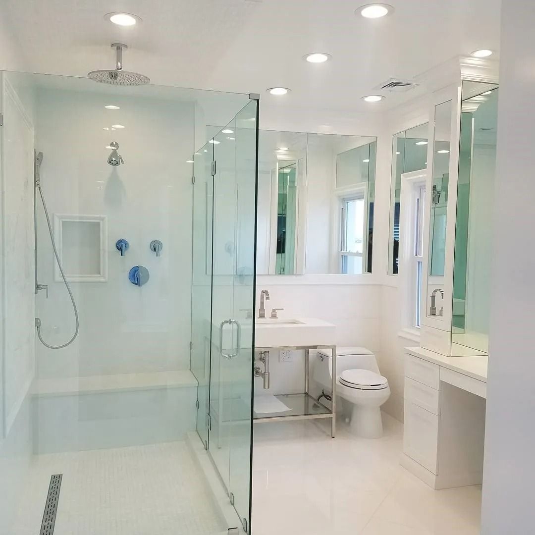 A bathroom with a toilet , sink , shower and mirrors