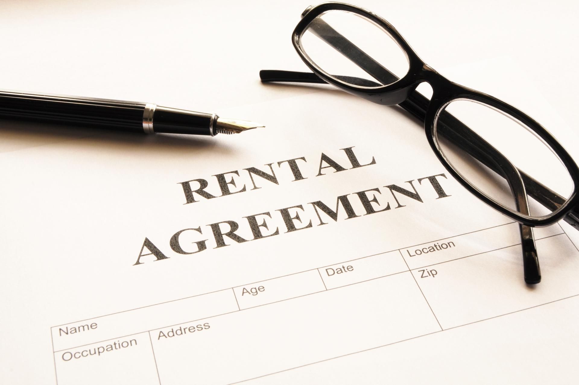 Glasses and a pen on a rental agreement document