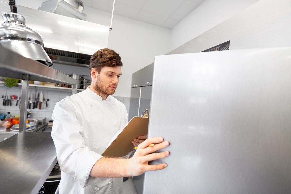 chef-with-checklist-for-commercial-refrigerator