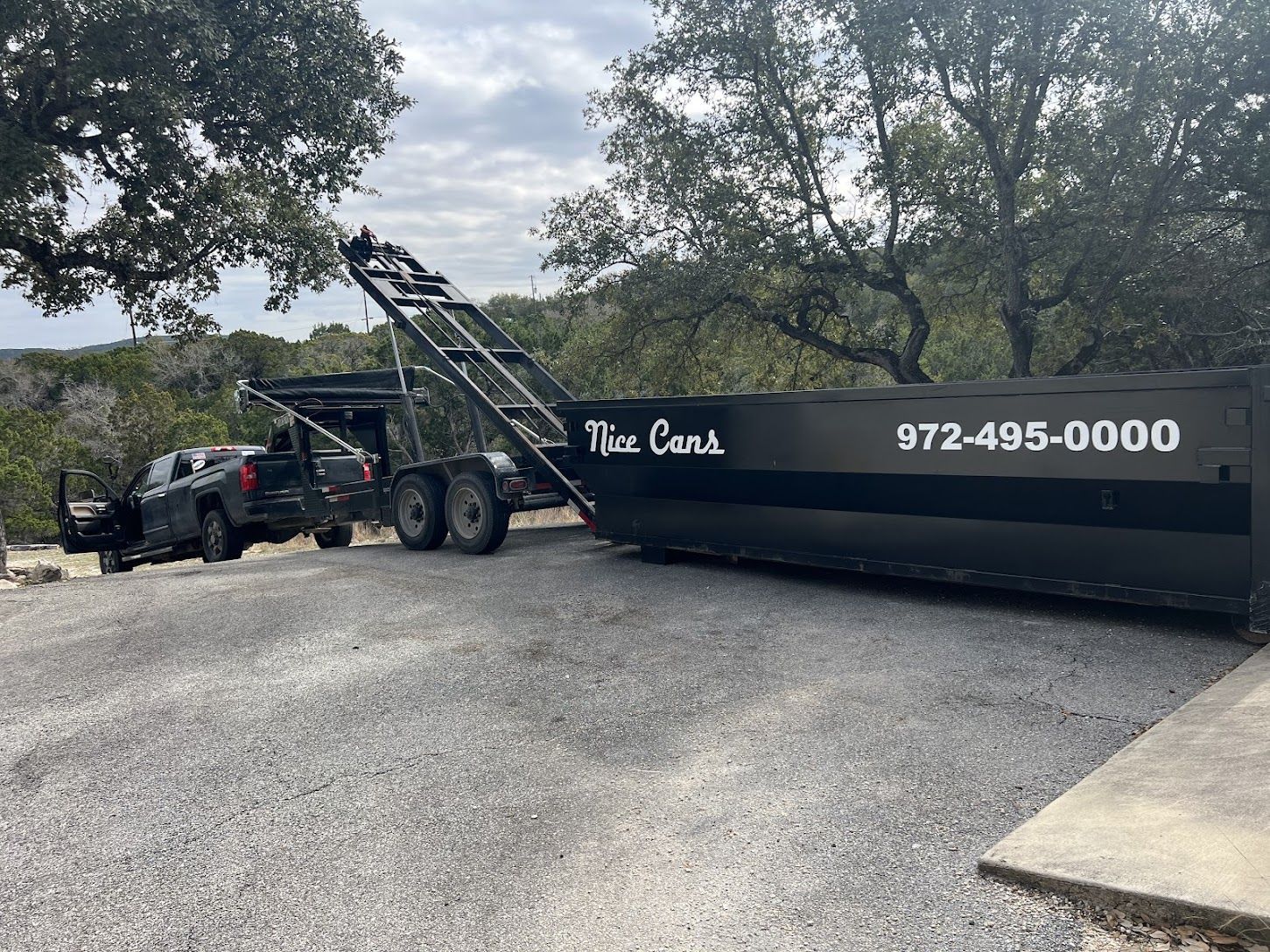 A dump truck is parked in a dirt field.