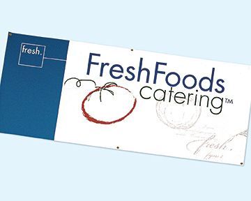 A fresh foods catering banner with a tomato on it