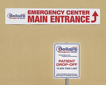 An emergency center main entrance sign and a patient drop off sign