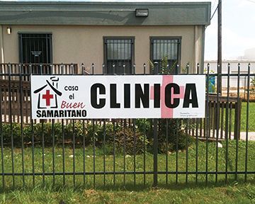 A sign on a fence that says casa el buen samaritano