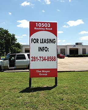 A red and white sign that says for leasing info