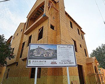 A building under construction with a sign in front of it that says iron gate