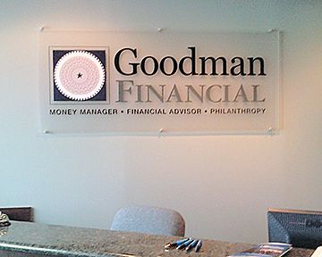 A goodman financial sign hangs above a desk