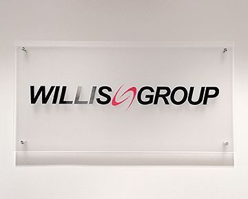 A willis group sign is hanging on a white wall.