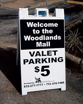 A sign that says welcome to the woodlands mall valet parking $ 5