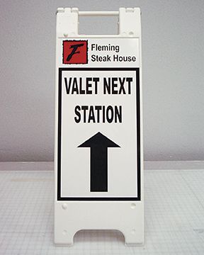 Valet next station sign with an arrow pointing to the right
