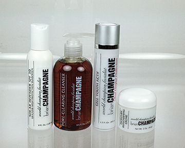 Four bottles of champagne cosmetics are sitting on a counter.