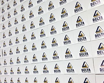 A wall of delta stickers on a white surface.
