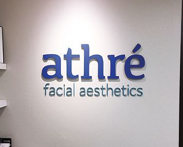 A sign on a wall that says athre facial aesthetics