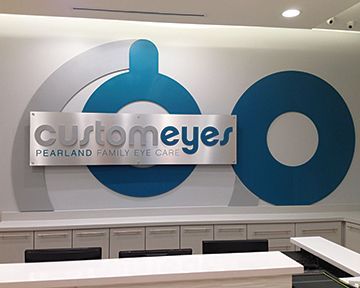 A sign on a wall that says customeyes pearlland family eye care