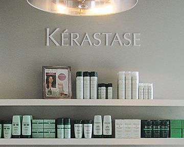 A shelf filled with hair products and a sign that says kerastase