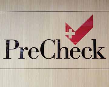 A sign that says precheck with a red check mark