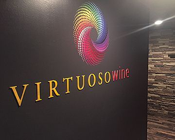 A sign on a wall that says virtuosowine on it
