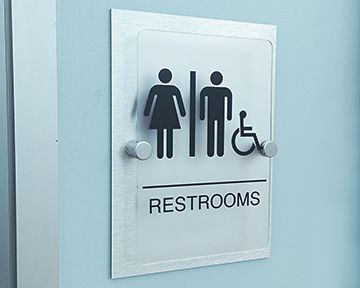 A sign for a restroom with a man and woman and a handicapped person.
