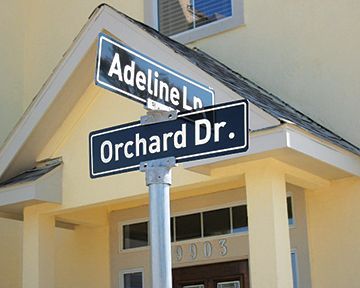A street sign for orchard dr. and adeline ln