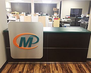 A reception desk with a logo on it in an office.