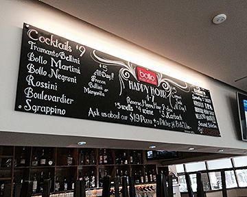 A chalkboard with a list of cocktails on it