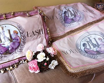 A couch with three pillows and flowers on it.