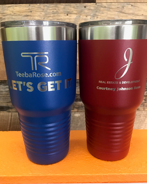 Two stainless steel tumblers one blue and one red are sitting on a table.