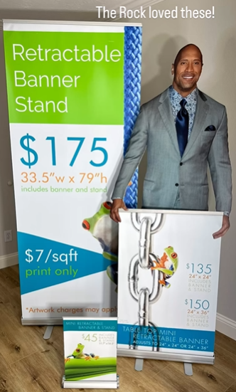 A man in a suit is holding a retractable banner stand.