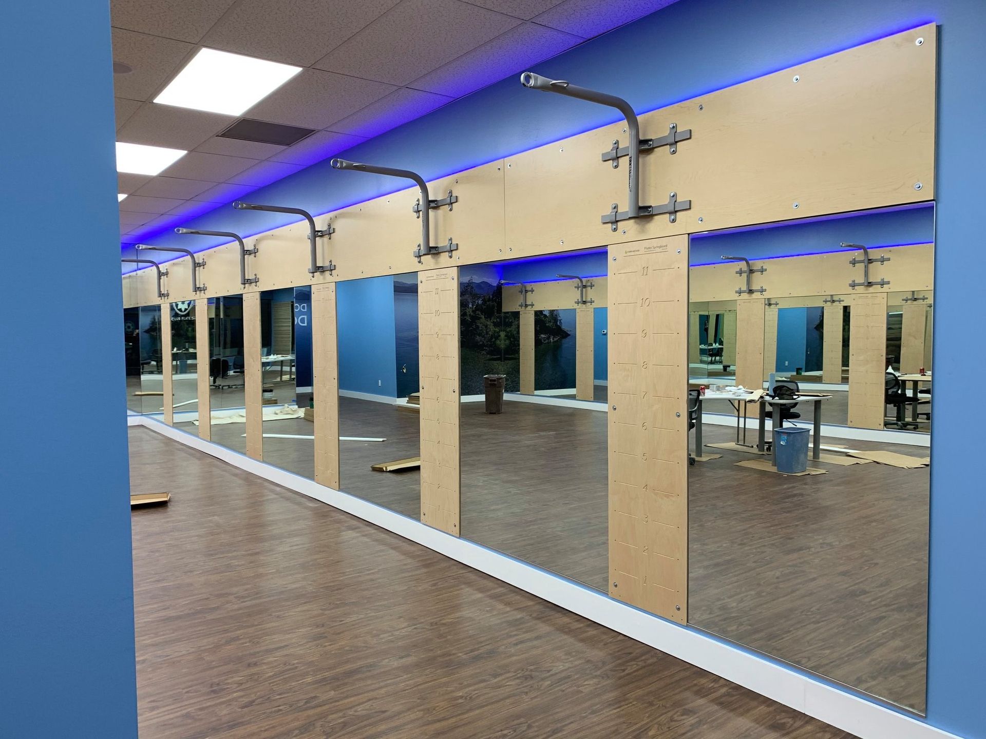 A gym with a lot of mirrors on the wall.