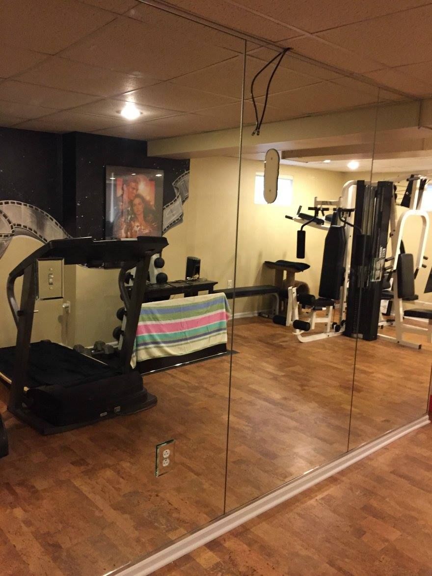A gym with a treadmill and a large mirror