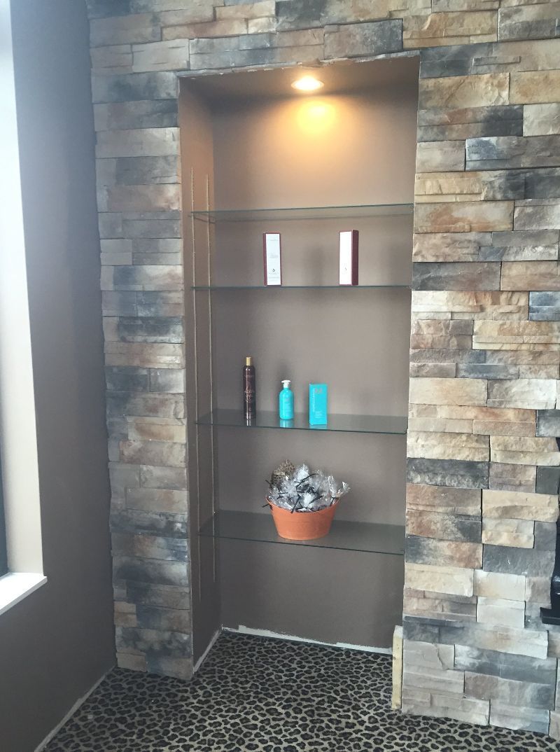 A brick wall with a shelf in the middle of it