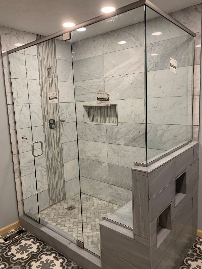 A bathroom with a walk in shower with sliding glass doors.