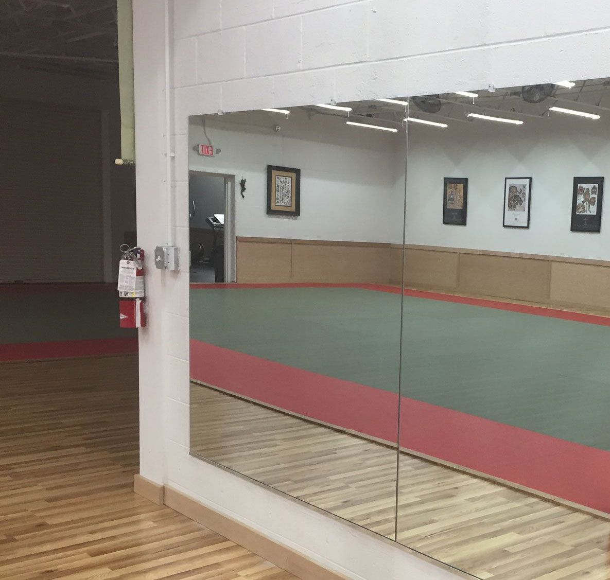 A room with a large mirror and a fire extinguisher