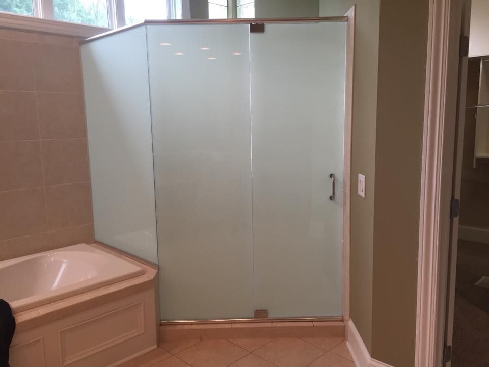 A bathroom with a bathtub and a shower stall