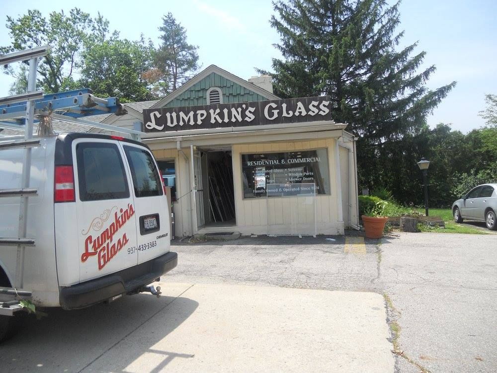 A white van is parked in front of lumpkins glass