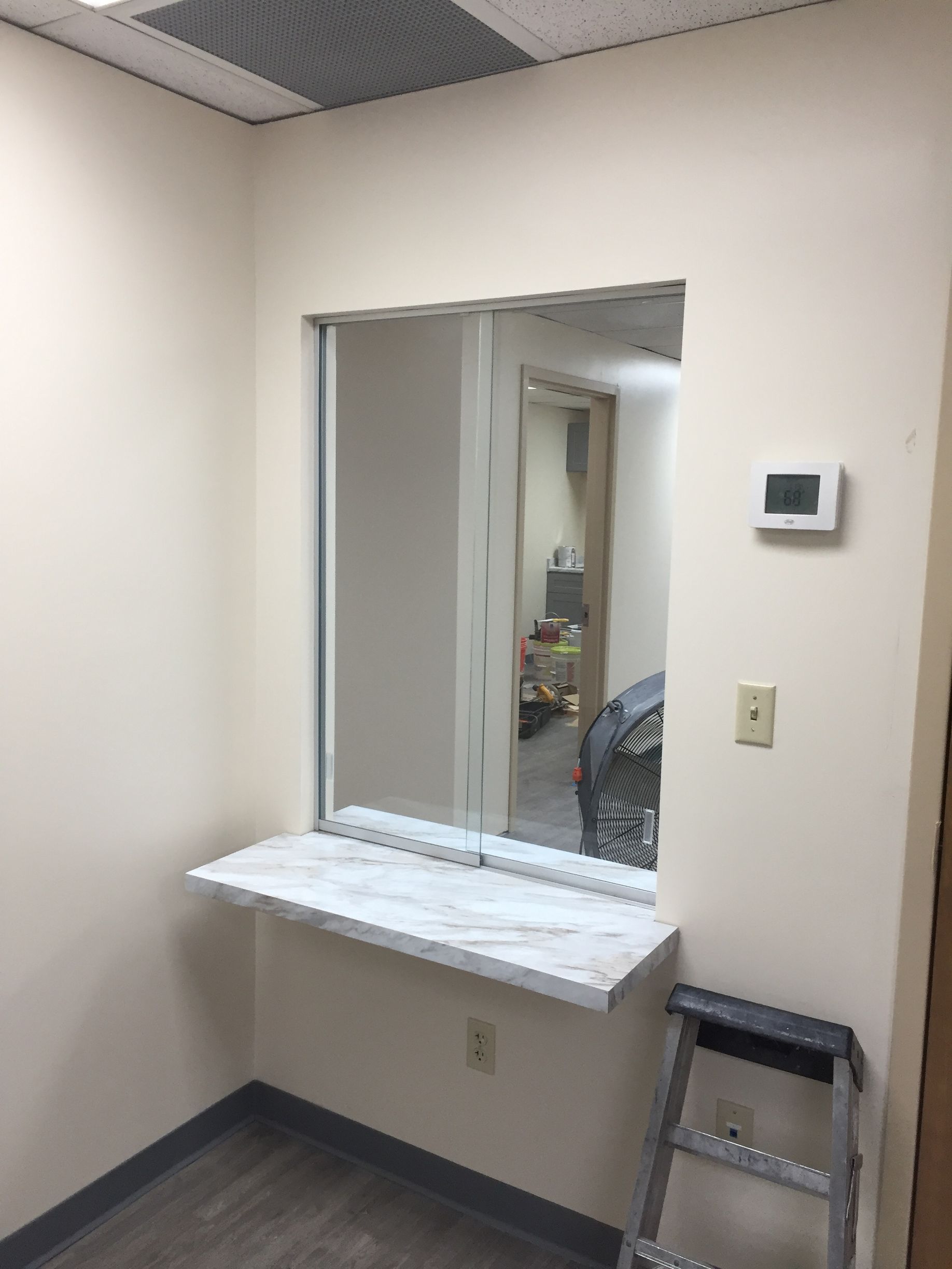 A room with a window and a ladder in it.