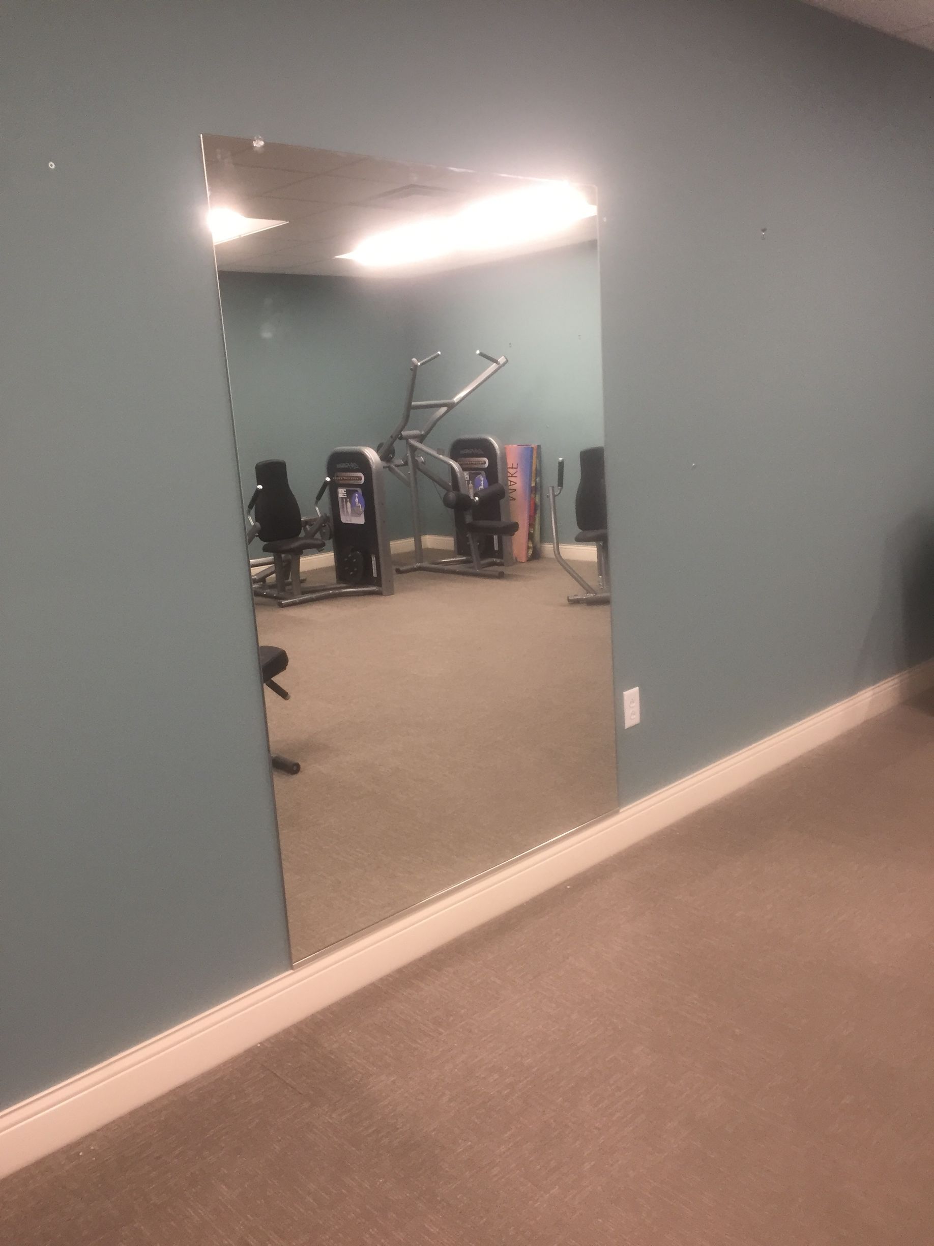 A gym with a large mirror on the wall.