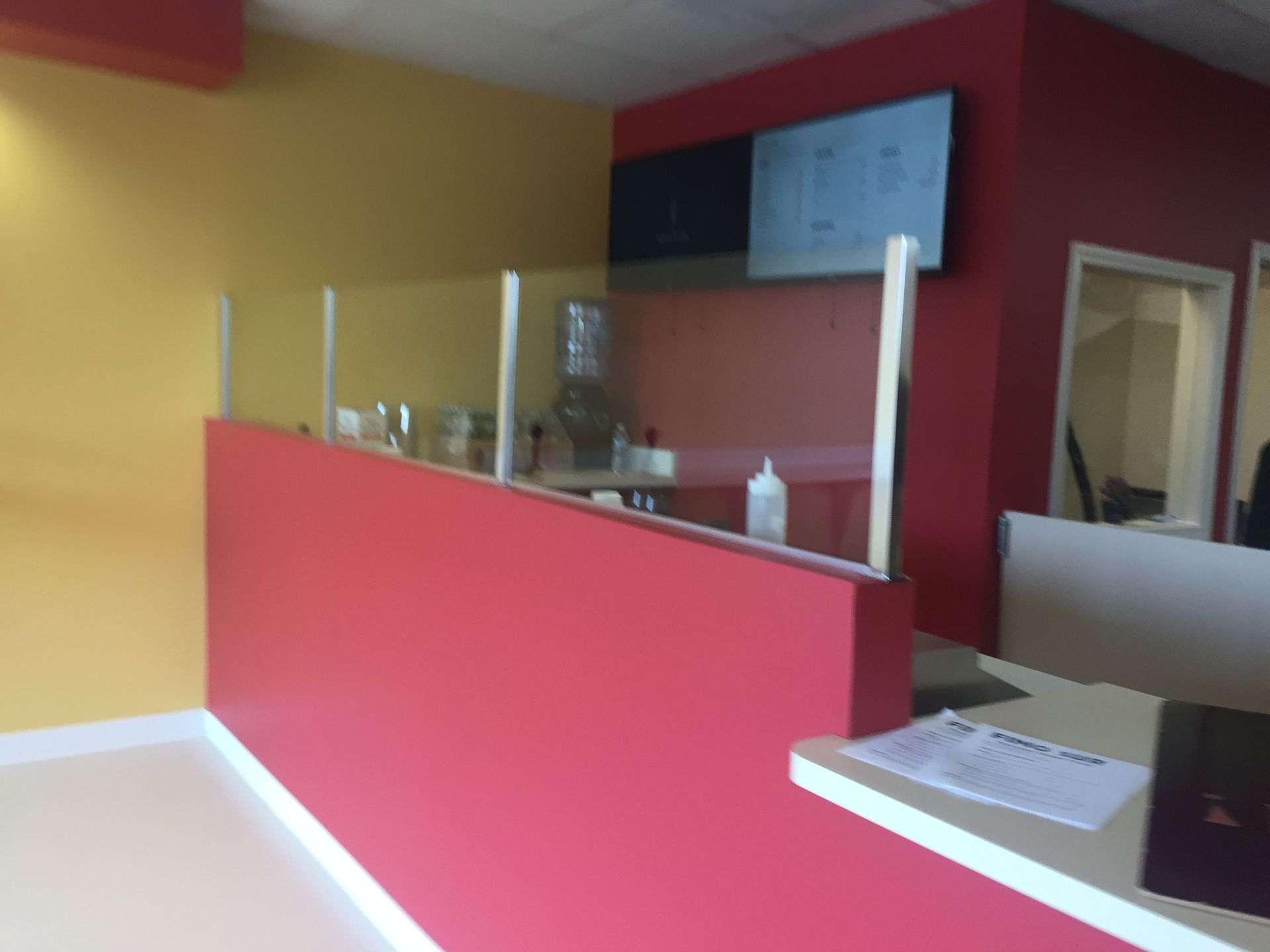 A red and yellow office with a glass divider