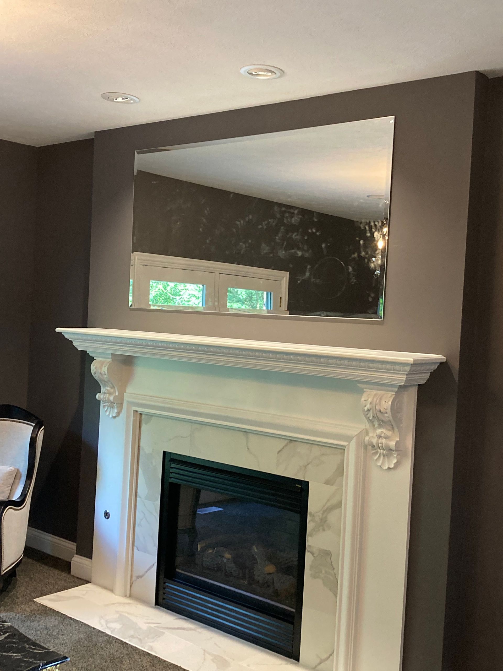 A living room with a fireplace and a large mirror on the wall.