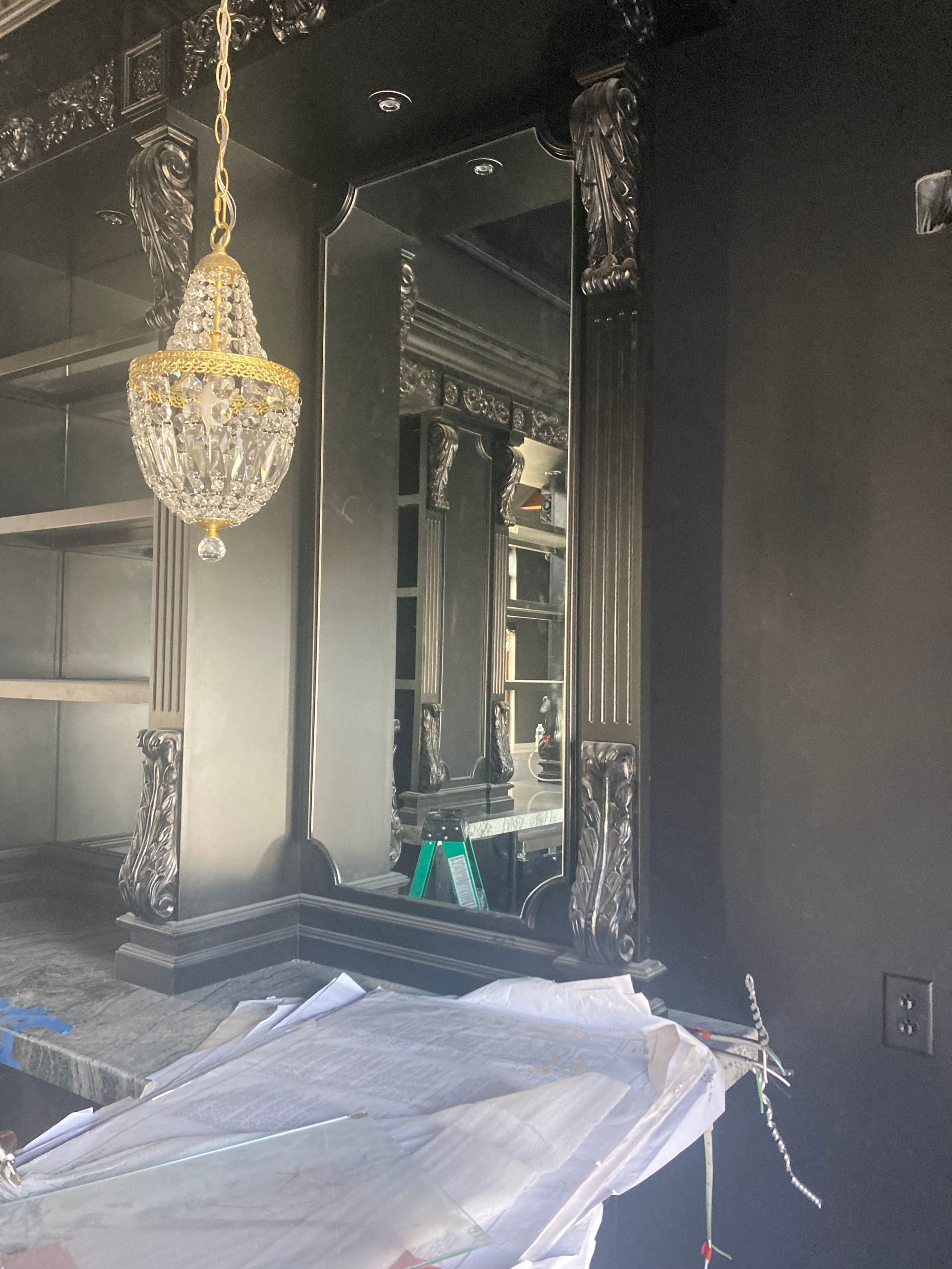 A room with a large mirror and a chandelier hanging from the ceiling