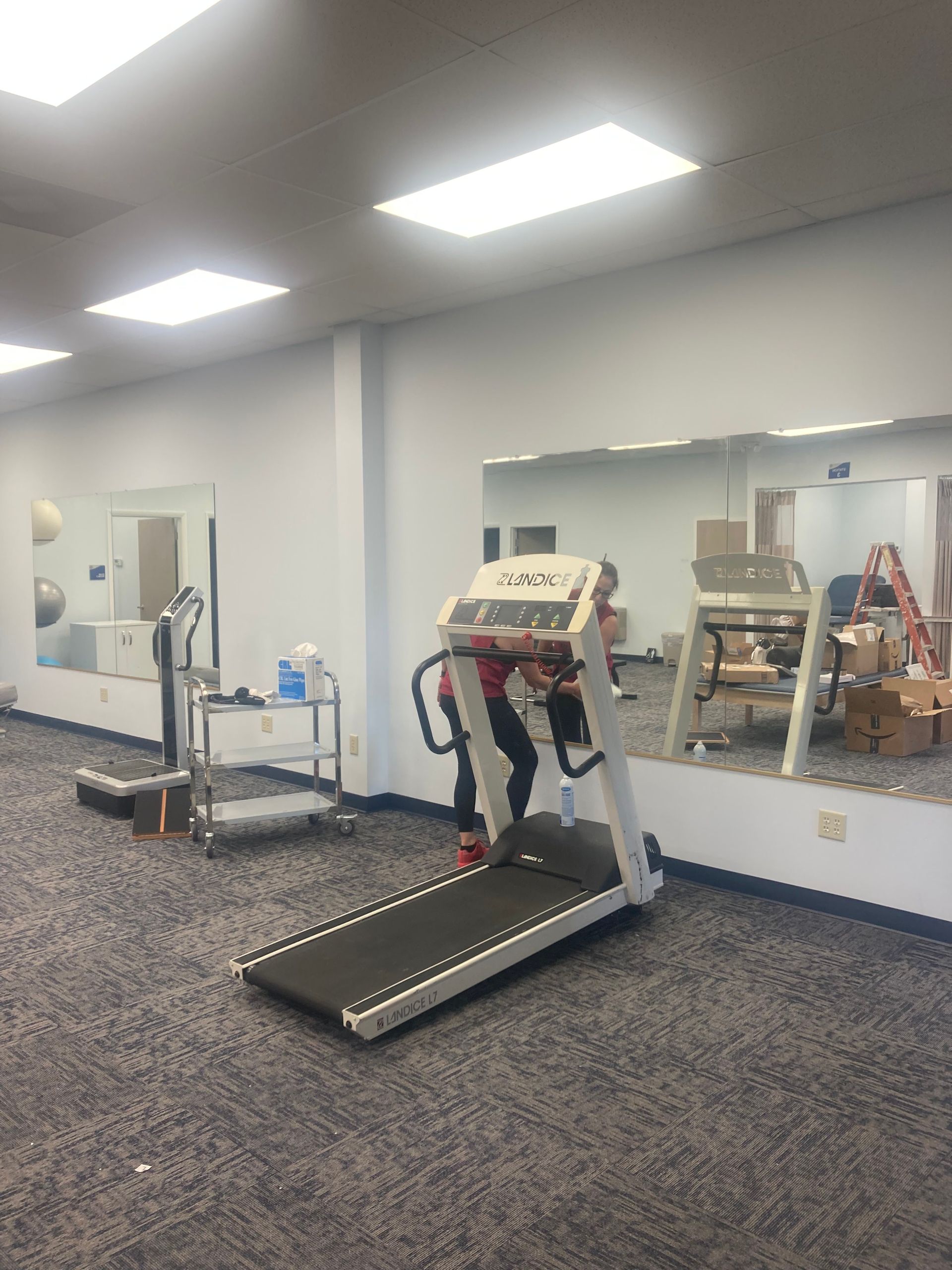 A treadmill is sitting in a room with a lot of mirrors.