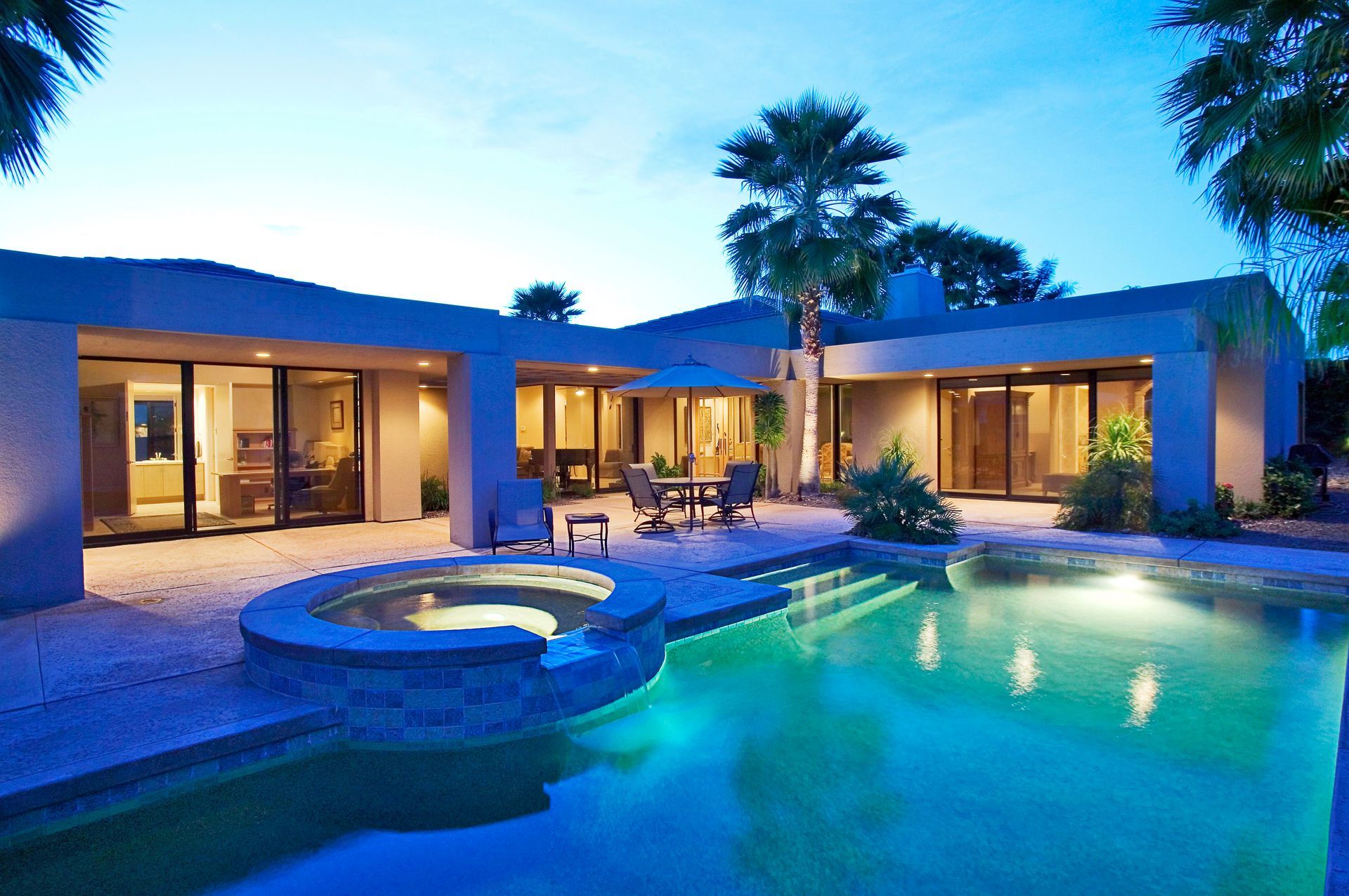 A large house with a swimming pool in front of it